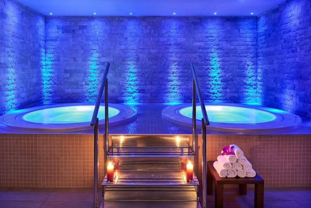 Two round hot tubs in a spa lit in blue